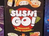 a box of sushi go next to a box of japanese food