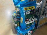 Plusieurs sacs de provisions sont empilés les uns sur les autres dans un magasin
