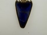a close up of a blue heart shaped pendant on a white surface