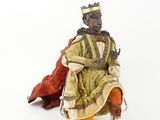 une figurine représentant un homme noir assis sur une chaise