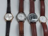 plusieurs types de montres sont alignés sur une surface blanche