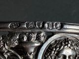 a close up of a silver plate with a face on it