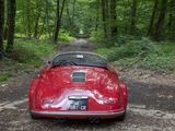 a red car parked on a dirt road in the woods