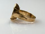 a gold ring with a diamond in it on a white surface