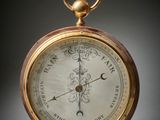 an antique pocket watch with a gold case and a white dial