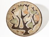 une assiette blanche ornée d'un motif d'arbre