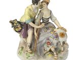 une figurine représentant un homme et une femme accompagnés d'un chien