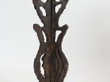 an image of a tall metal vase with a decorative design on it