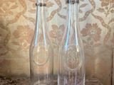 deux bouteilles en verre vides posées sur une table en marbre