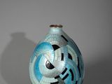 un vase bleu orné d'un motif en noir et blanc