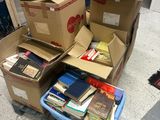 de nombreuses caisses de livres empilées les unes sur les autres par terre