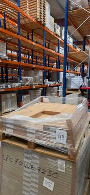 Les cartons sont empilés sur des palettes dans un grand entrepôt rempli de palettes
