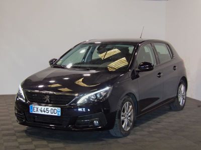 La voiture noire est garée dans le showroom, sur le sol à damier.