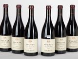six bouteilles de vin rouge sont alignées sur une table