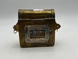 an old brass box with a handle on a white surface