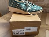 pair of blue and white shoes sitting on top of a cardboard box