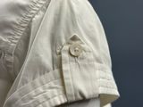 a close up of a white shirt with a button on it