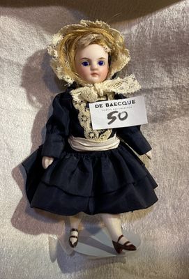 a doll that is holding a sign with a name on it