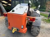 a small orange tractor parked in a lot