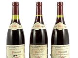 trois bouteilles de vin sont alignées sur une surface blanche