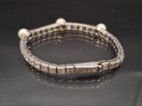 an image of a diamond and pearl bracelet on a black surface
