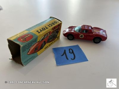 une petite voiture rouge à côté d'une boîte sur laquelle figure un numéro