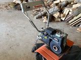 une petite machine posée au milieu d'un tas de bois