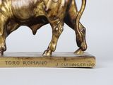 a statue of a bull that is standing on a wooden base