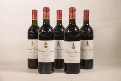 quatre bouteilles de vin rouge sont alignées sur une surface blanche