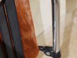 a chair that has a leather seat and a metal handle
