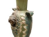 a green vase with a face on it on a white background