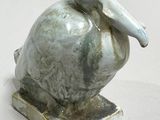 a statue of a bird sitting on top of a base