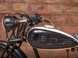 a black and white motorcycle parked in front of a brick wall