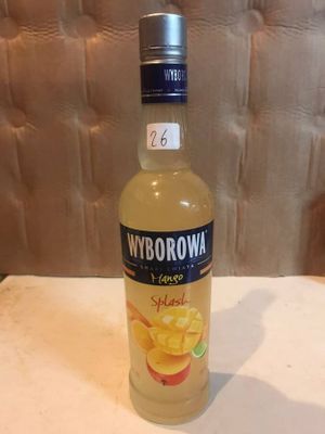 a bottle of liquor sitting on a table in front of a wall