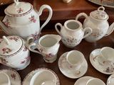 a table with a lot of tea and coffee cups and saucers