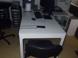 un bureau blanc avec une chaise noire et un ordinateur posé dessus