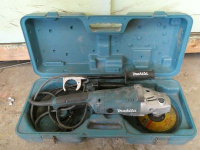 une caisse à outils bleue avec des outils sur le sol