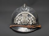 an old helmet with a coat of arms on it on a black background