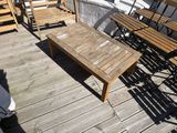 many wooden chairs and tables on the deck of a boat
