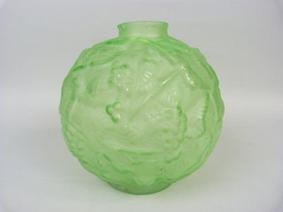 a green glass vase that is sitting on a white surface