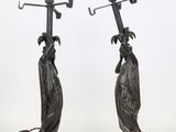 a pair of bronze statues of women with umbrellas on their heads