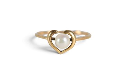 a close up of a gold ring with a pearl in the middle