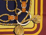 a yellow and red scarf with a rope and a buckle
