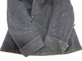 a blue jacket with a hood on it sitting on a white surface