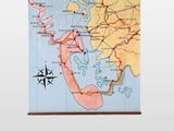 map of the world hanging on a wall with a compass on it