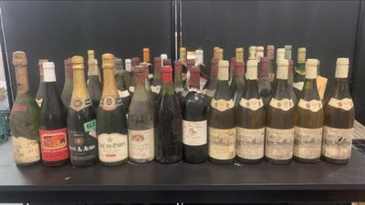 des bouteilles de vin sont alignées sur une table dans une pièce