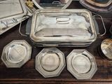 a lot of silver plates and trays on a table