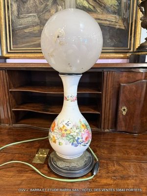 une lampe posée sur une table devant un tableau