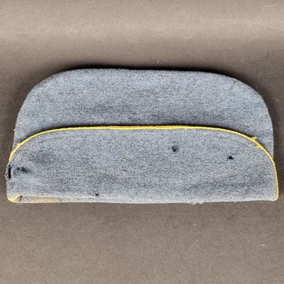 une pochette grise et jaune à fermeture éclair posée sur une surface marron