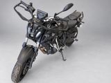 a black motorcycle that is parked on a gray surface